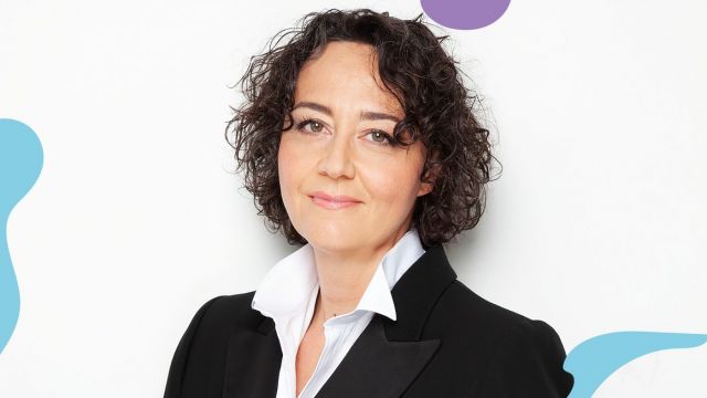 Bilde av kvinne med halvlangt krøllete mørkt hår som smiler.
