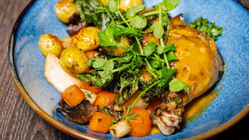 Bilde av hovedrett på tallerken. Konfitert kyllinglår.