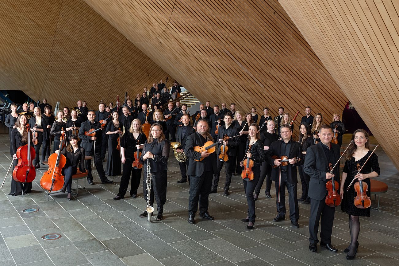 Bilde av orkester kledd i sort som holder instrumentene sine