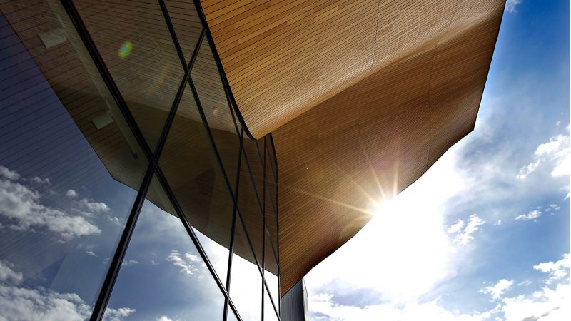 Bilde av vinduer og et bølgete tak med sola i bakgrunnen