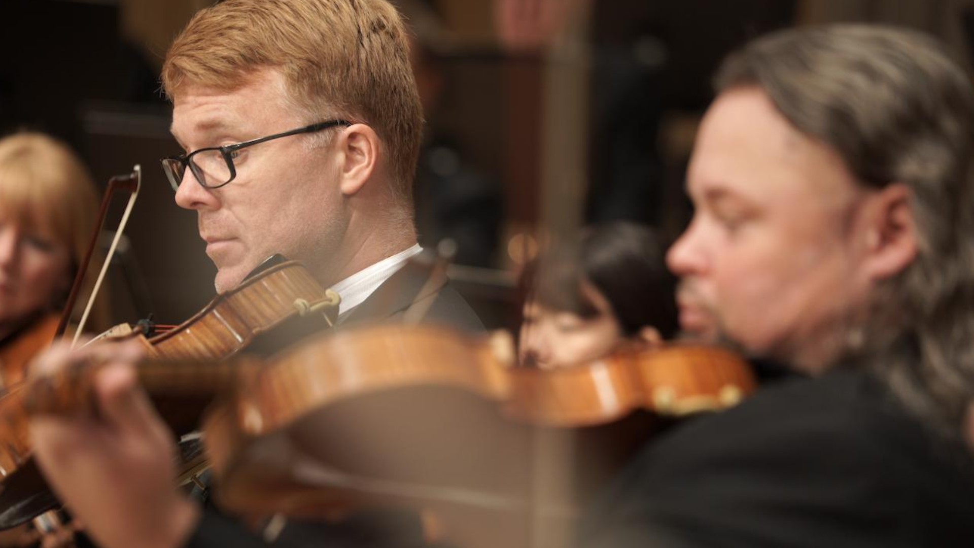 Nærbilde av musiker i KSO i pent tøy og med instrument