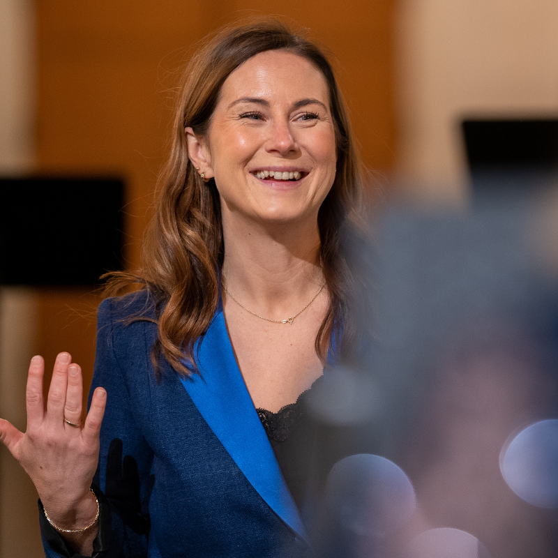 smilende dame med blå dressjakke