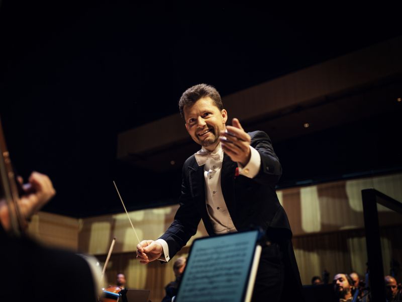 sjefdirigent for KSO julian rachlin strekker seg mot publikum fra podiet i konsertsalen