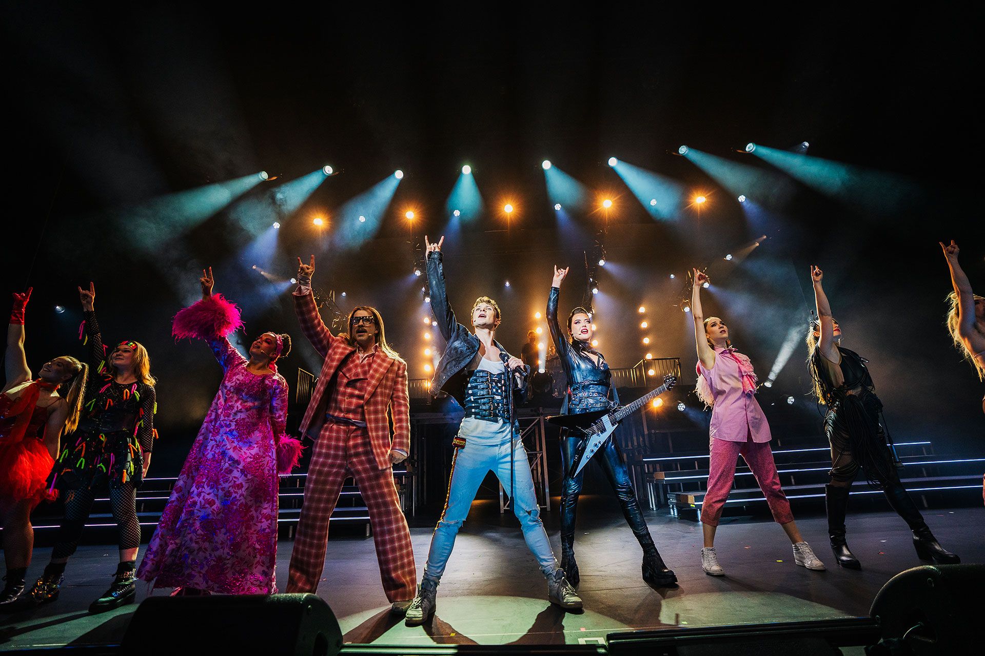 Forestillingsbilde fra Sister Act. Damer i nonne-kostyme danser på scenen.
