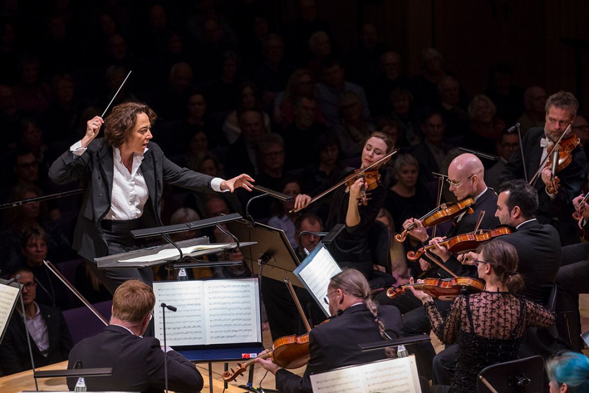 Tre musikere i et orkester som spiller