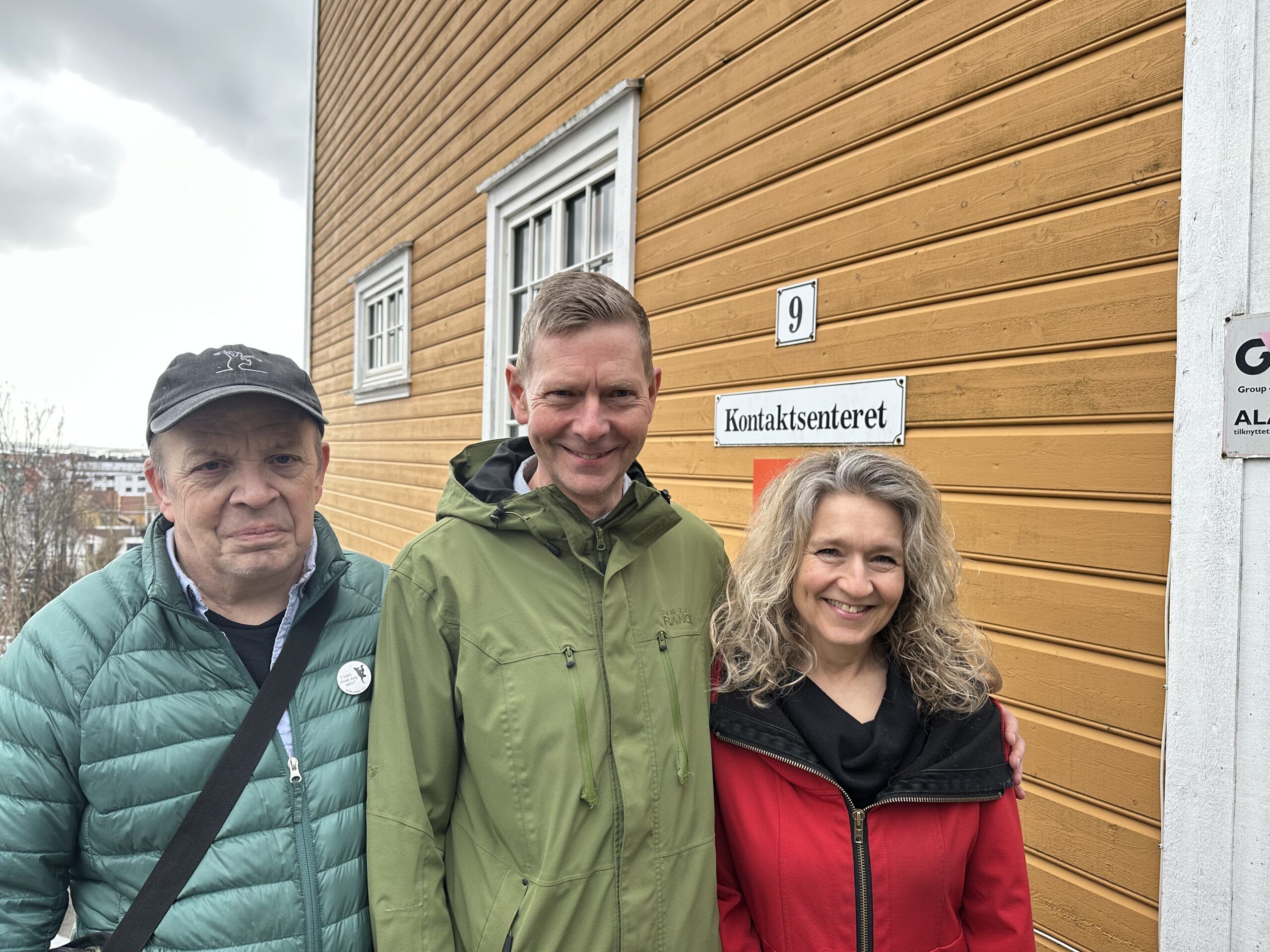 Tre arrangører poserer utenfor Kontaktsernteret.