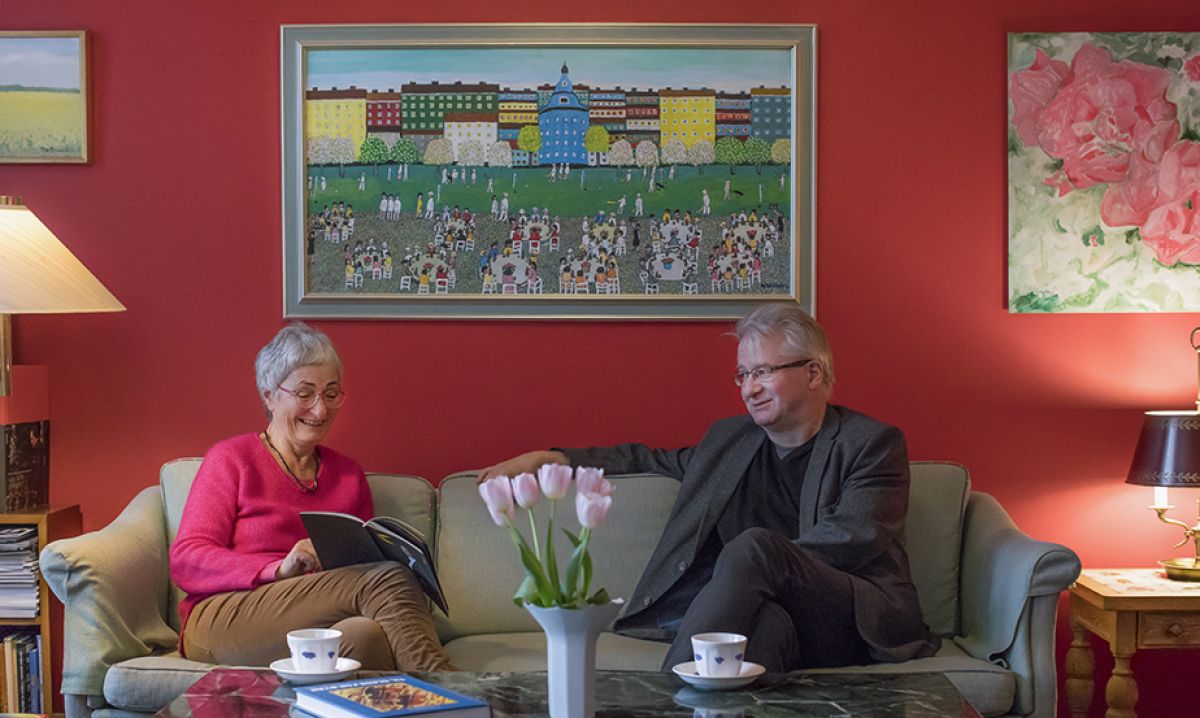 Bilde av Tulla Wahlstedt og Hans Bodin som ser i sesongprogrammet, sittende i en grå sofa.