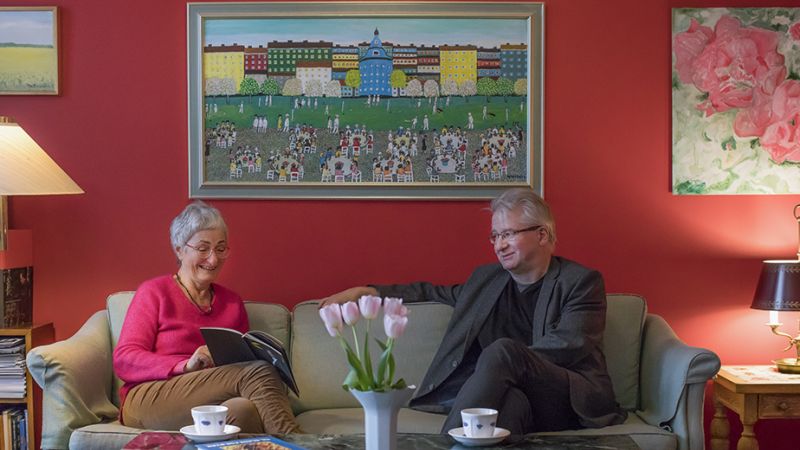Bilde av Tulla Wahlstedt og Hans Bodin som ser i sesongprogrammet, sittende i en grå sofa.