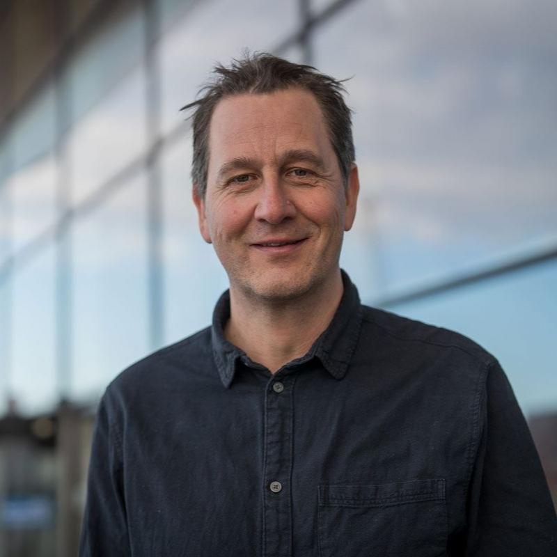 et portrettbilde av norsk skuespiller foran glassvegg