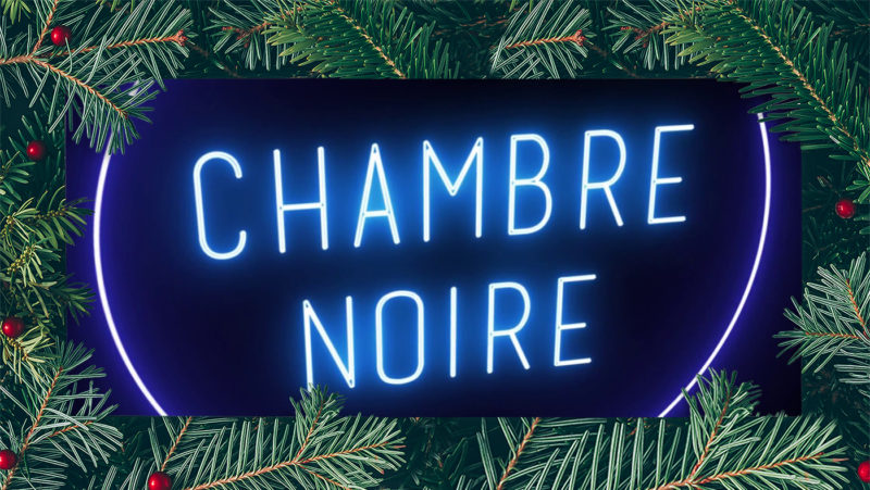 Skilt med skrift Chambre Noire i blått neonlys.