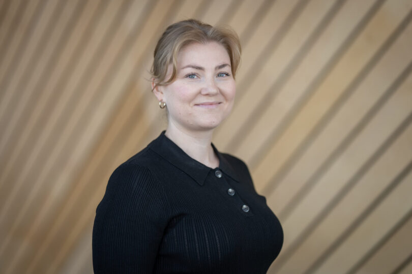 Portrettbilde av en smilende kvinne i mørk blå genser.