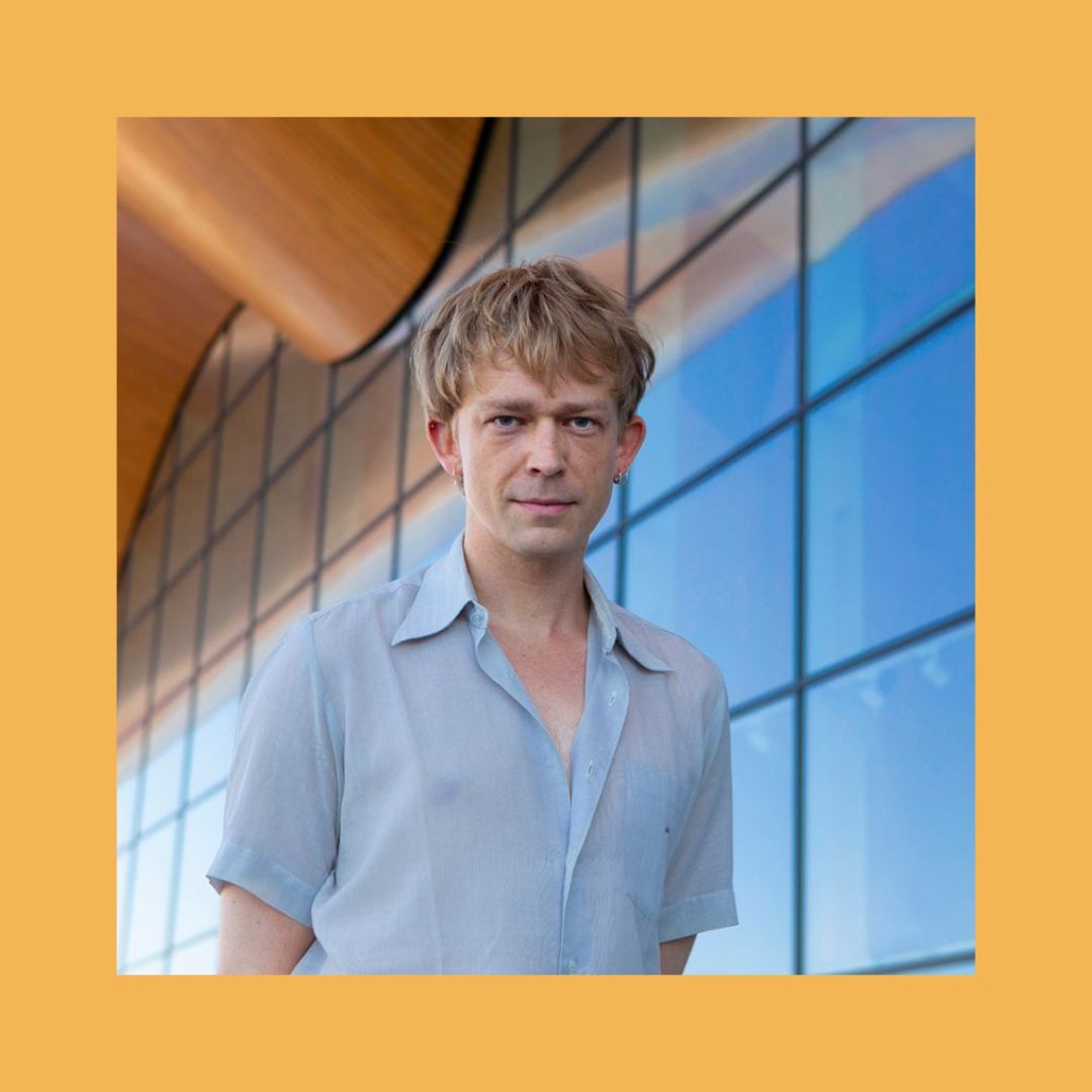 Portrait of Fredrik Høstaker against an orange background.