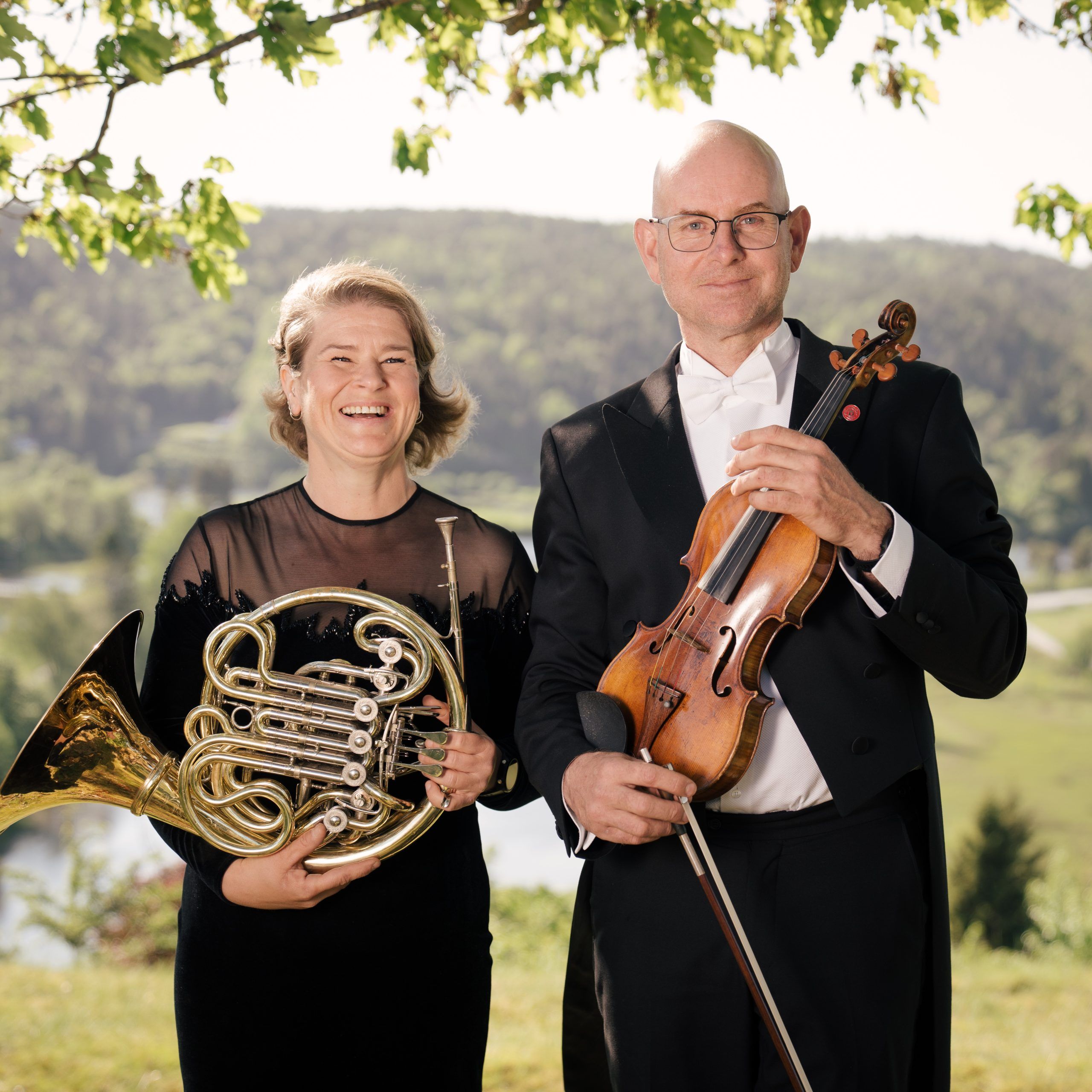 Hilde Garby Lunde og Lars Lunde i en åker i naturskjønne omgivelser