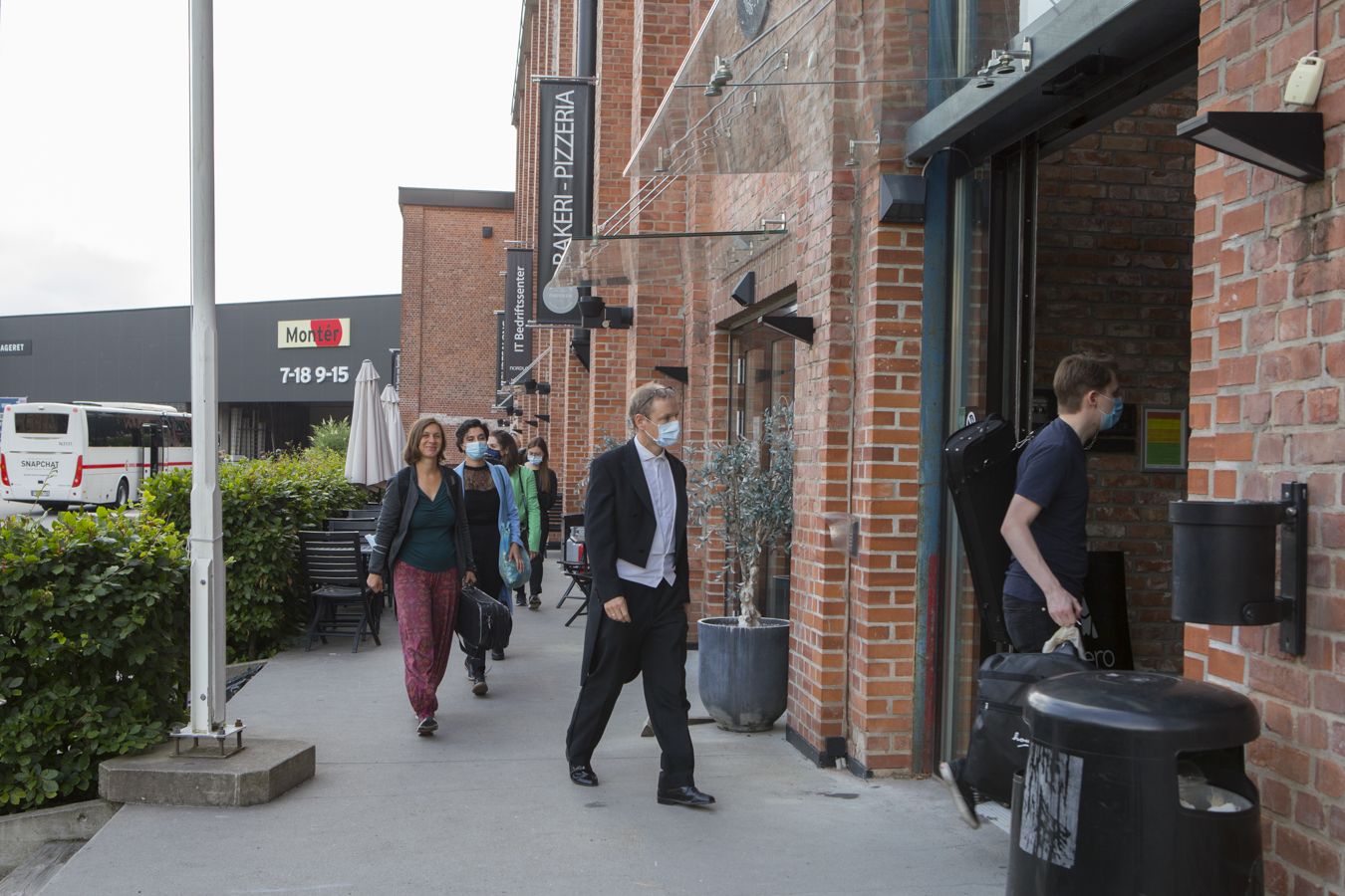 Mennesker gående inn i en murbygning.