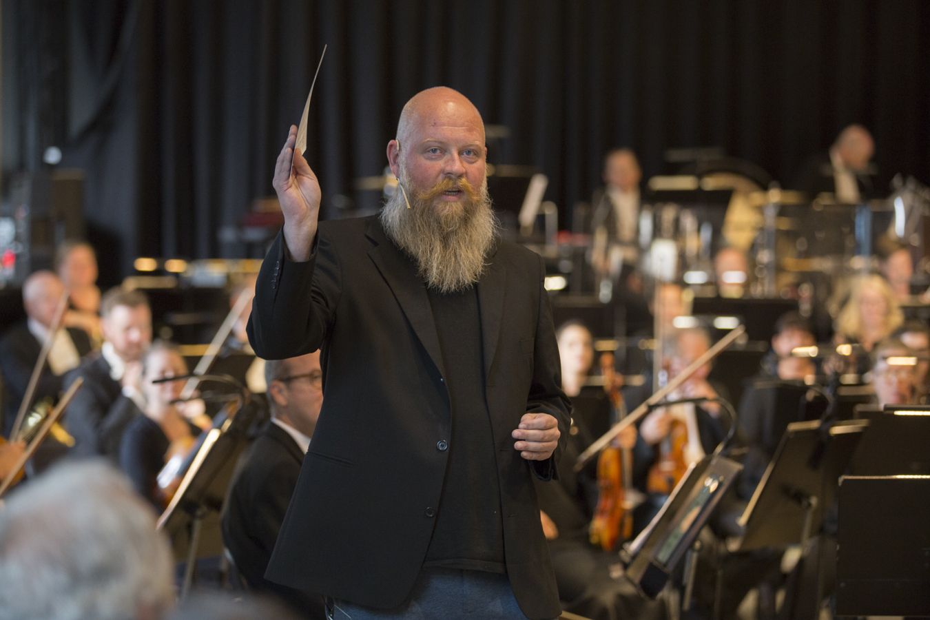 Mann med skjegg som prater og gestikulerer