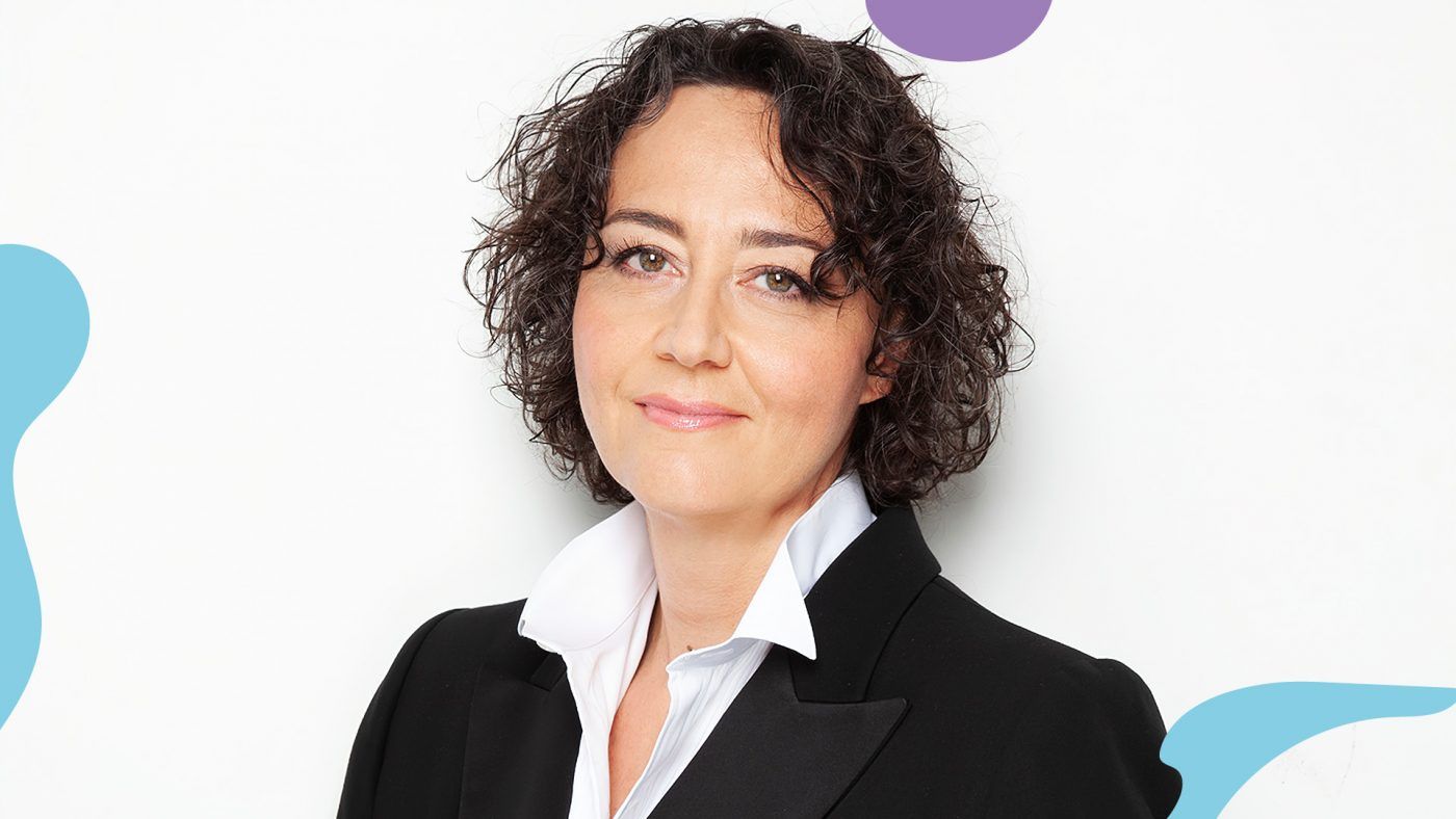 Bilde av kvinne med halvlangt krøllete mørkt hår som smiler.