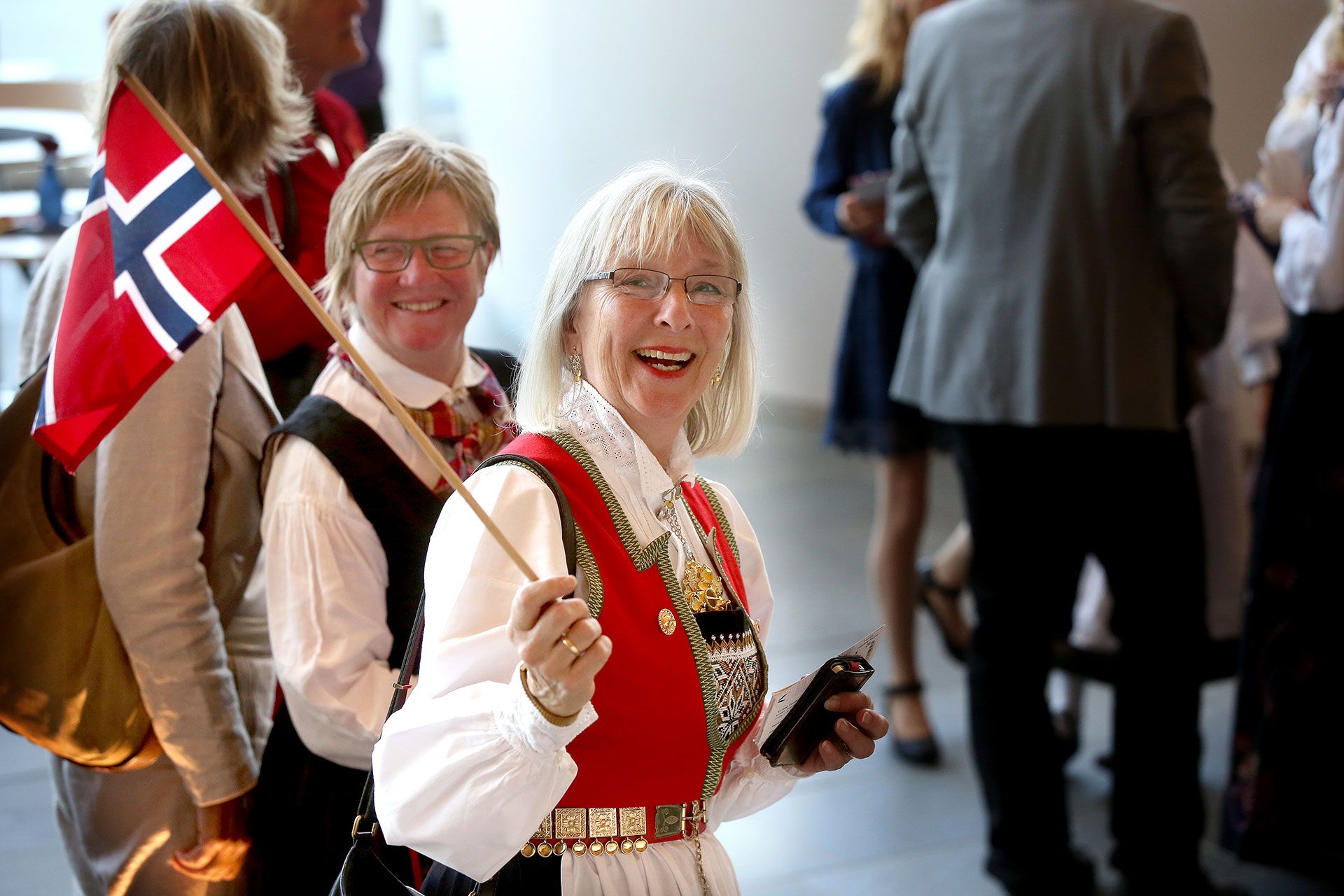 Smilende dame i bunad med norsk flagg