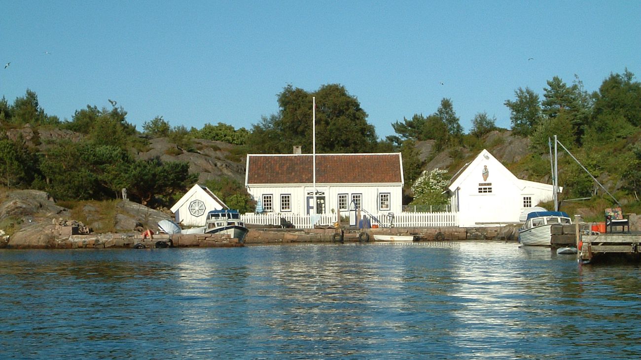 Hvite sørlandshus ved sjøen.