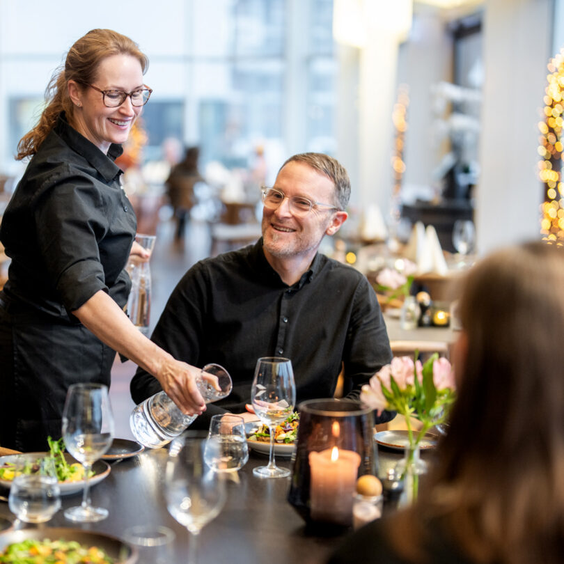 Photo of a server serving a smiling customer at Restaurant Frihavn