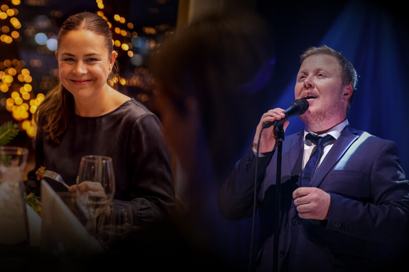Bilde av kvinne som spiser i Restaurant Frihavn. Det er julebord og varm stemning. Kvinnen smiler til andre ved bordet. Det er også bilde av vokalisten Kurt Nilsen.